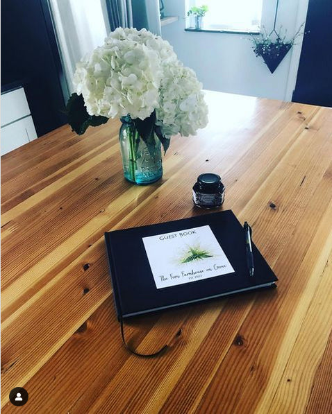 Black guest book for an Airbnb with custom logo on cover, perfect for collecting guest messages, suggestions and memories.
