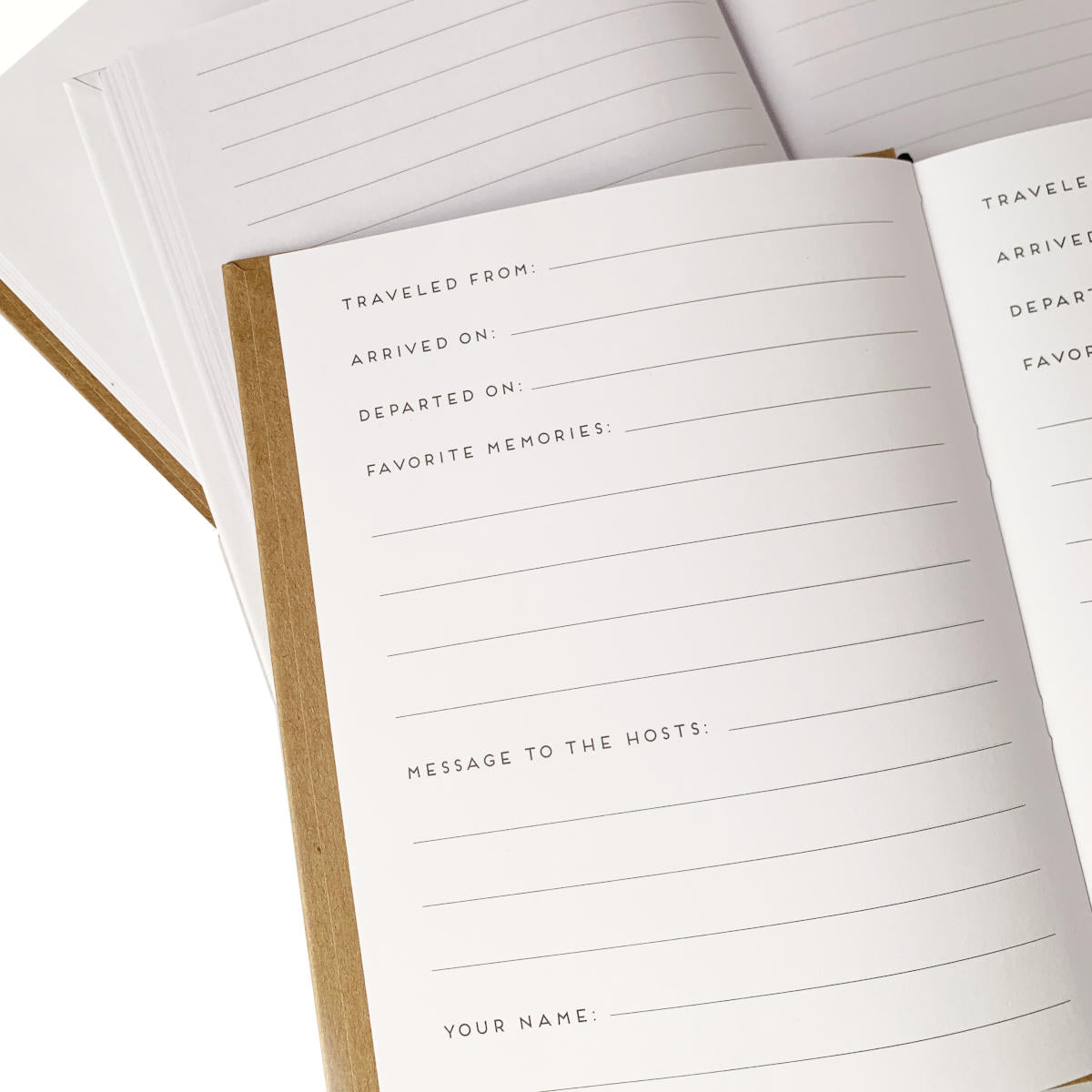 Custom guest books laying open, showing page options: blank, lined, and pages with prompts for visiting house guests.