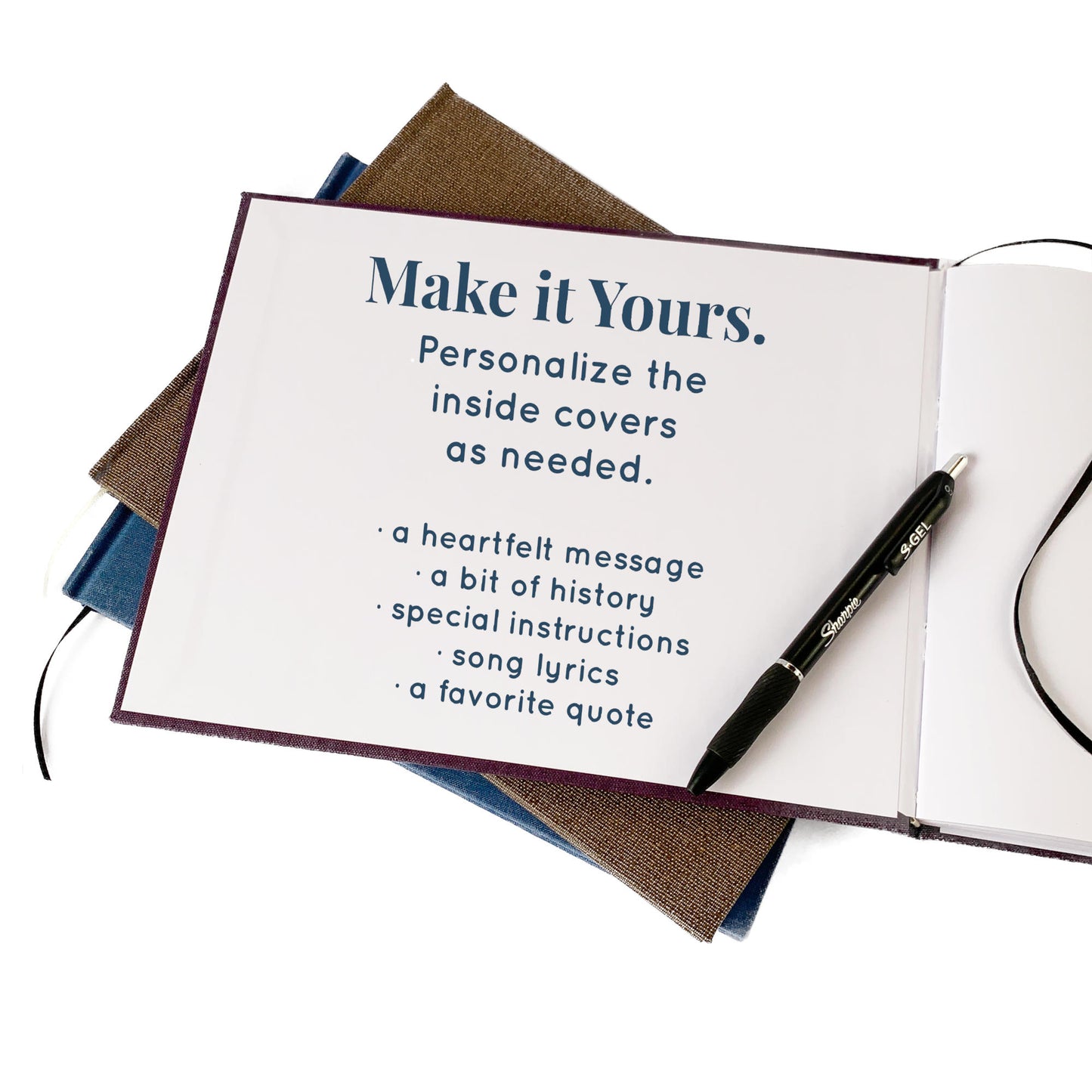 Open hand bound guest book with custom text printed on inside cover and pen on a white background