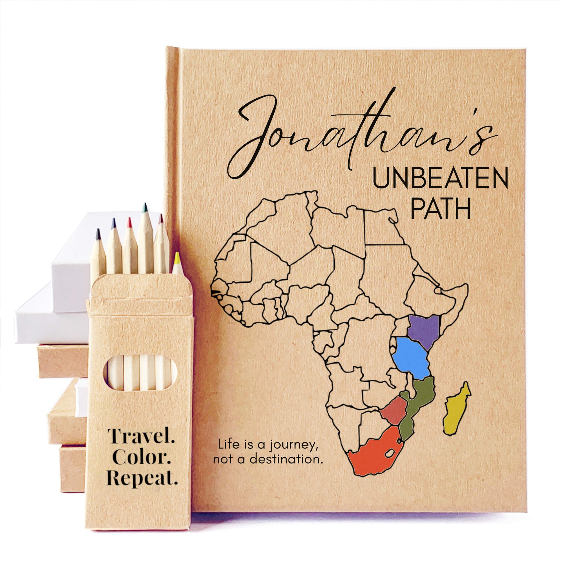 Custom travel journal, handbound, hardback, heirloom quality. Notebook with Africa map and colored regions, accompanied by colored pencils and a pencil case.