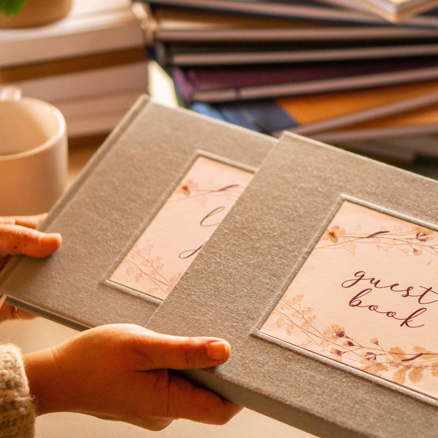 hands holding a book going into a book slipcase. hardback, linen fabric finish, handcrafted, made to order. exquisite presentation and protection of keepsake book.