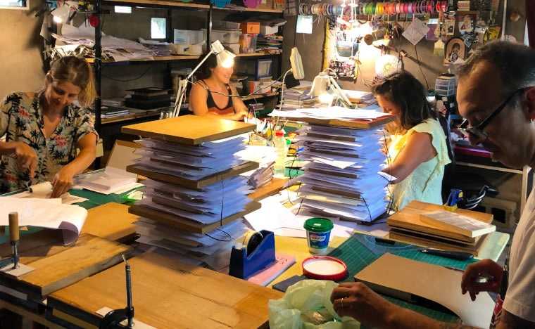 Team of bookbinders making personalized books one at a time.