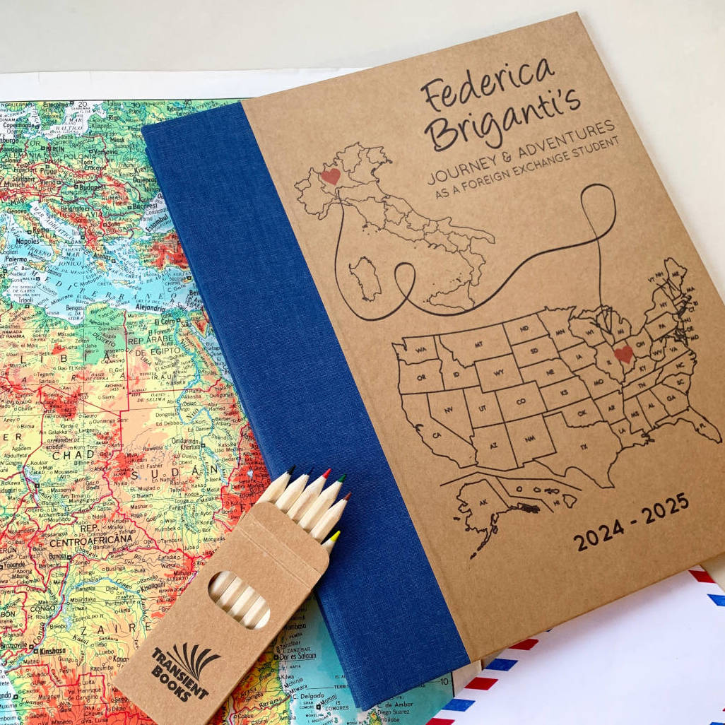 Personalized travel scrapbook with map design on a world map background. Hardback travel screwpost binder with removable pages, custom text, hardback cover.