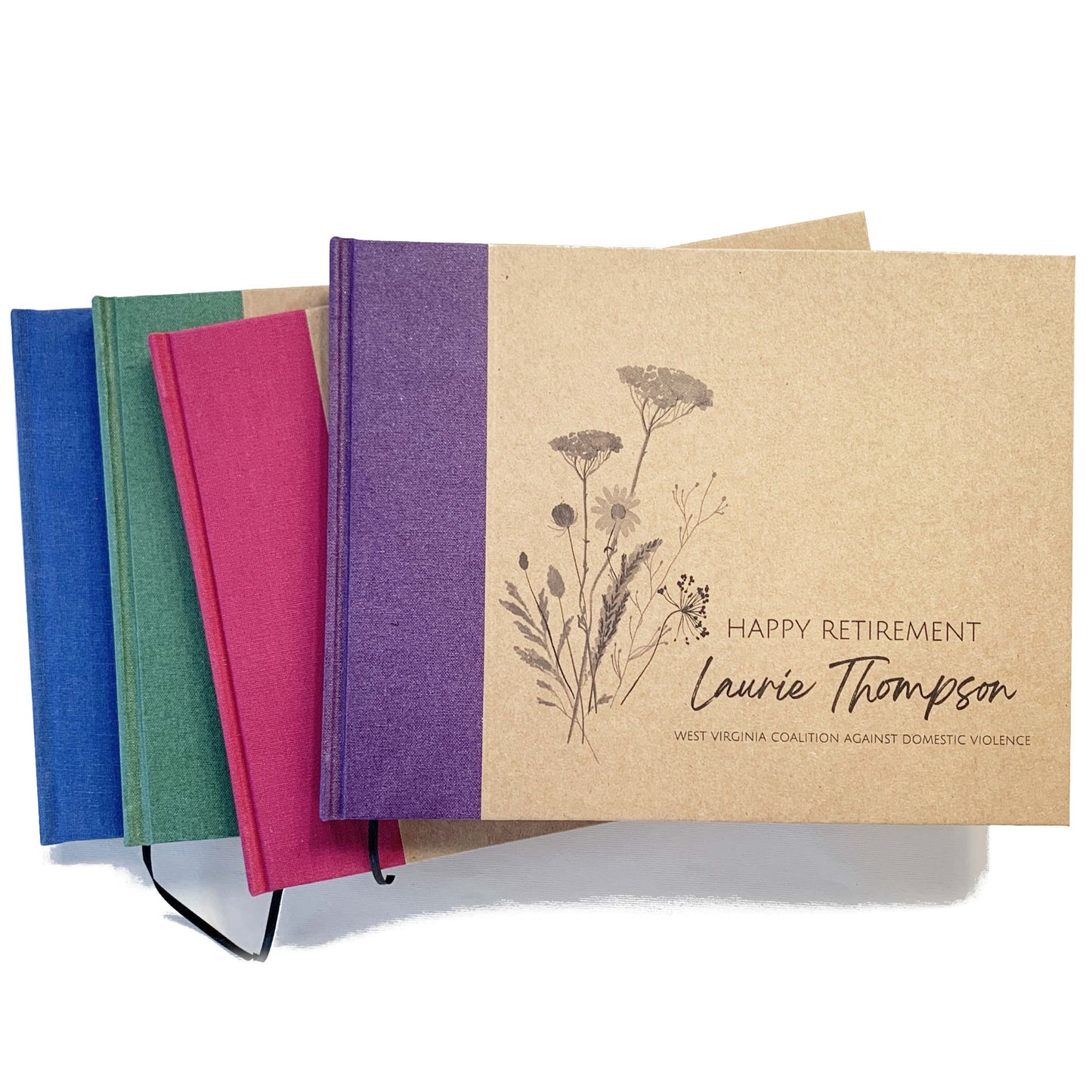 Set of personalized retirement guest books with a variety spine canvas colors. Hardback with personalized wildflower artwork cover design with custom names and text.