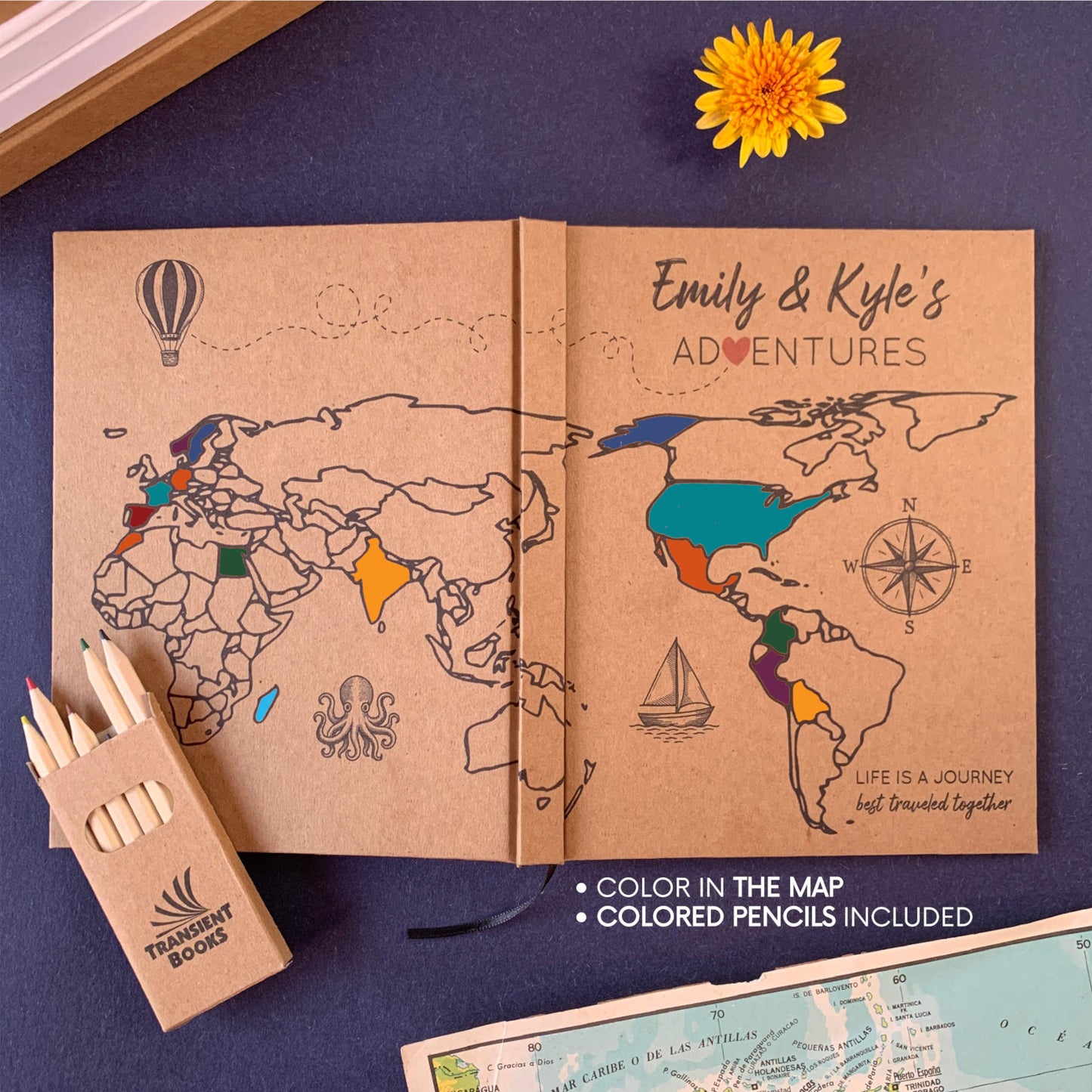 World map coloring book with colored pencils on a navy blue background. Personalized cover. Map colored in. Handcrafted, hardback cover. Cover design spans both back and front cover.