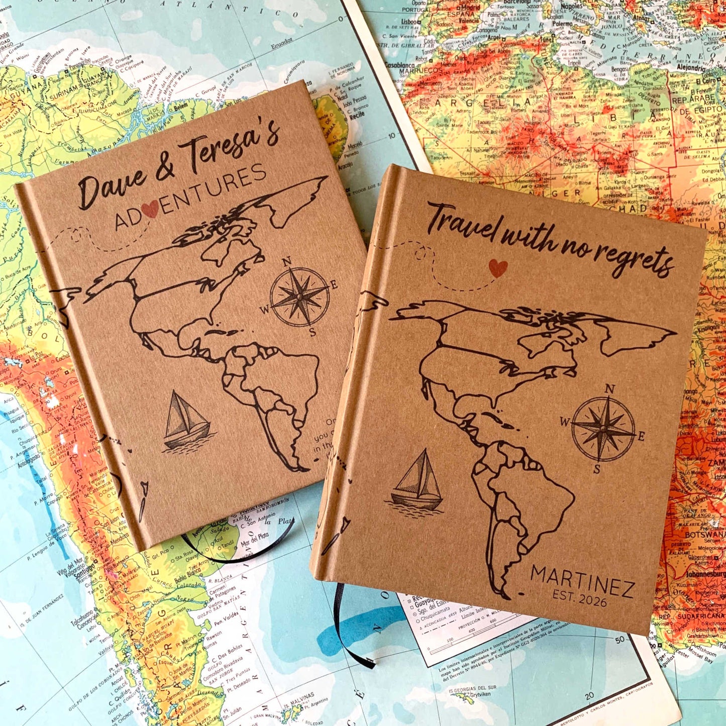 Two world travel journals, hardback, personalized, with world maps for coloring in. Custom cover text and artwork. Laying together on vintage world maps.