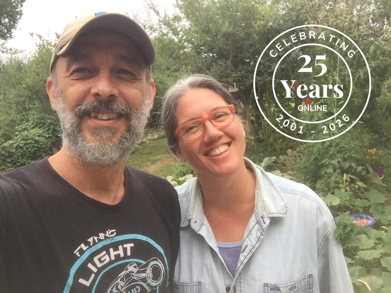 Two happy bookbinders in front of their bindery, with a stamp that says "celebrating 25 years online" at the Transient Books bindery.