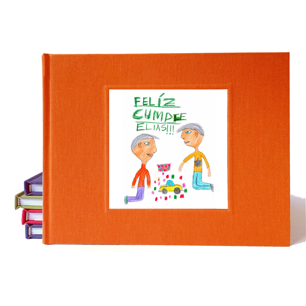 Bright orange birthday party guest book idea with personalized illustration on the cover drawn by a kid. The drawing is of 2 kids playing with cars and it says "Feliz Cumple Elias!!"