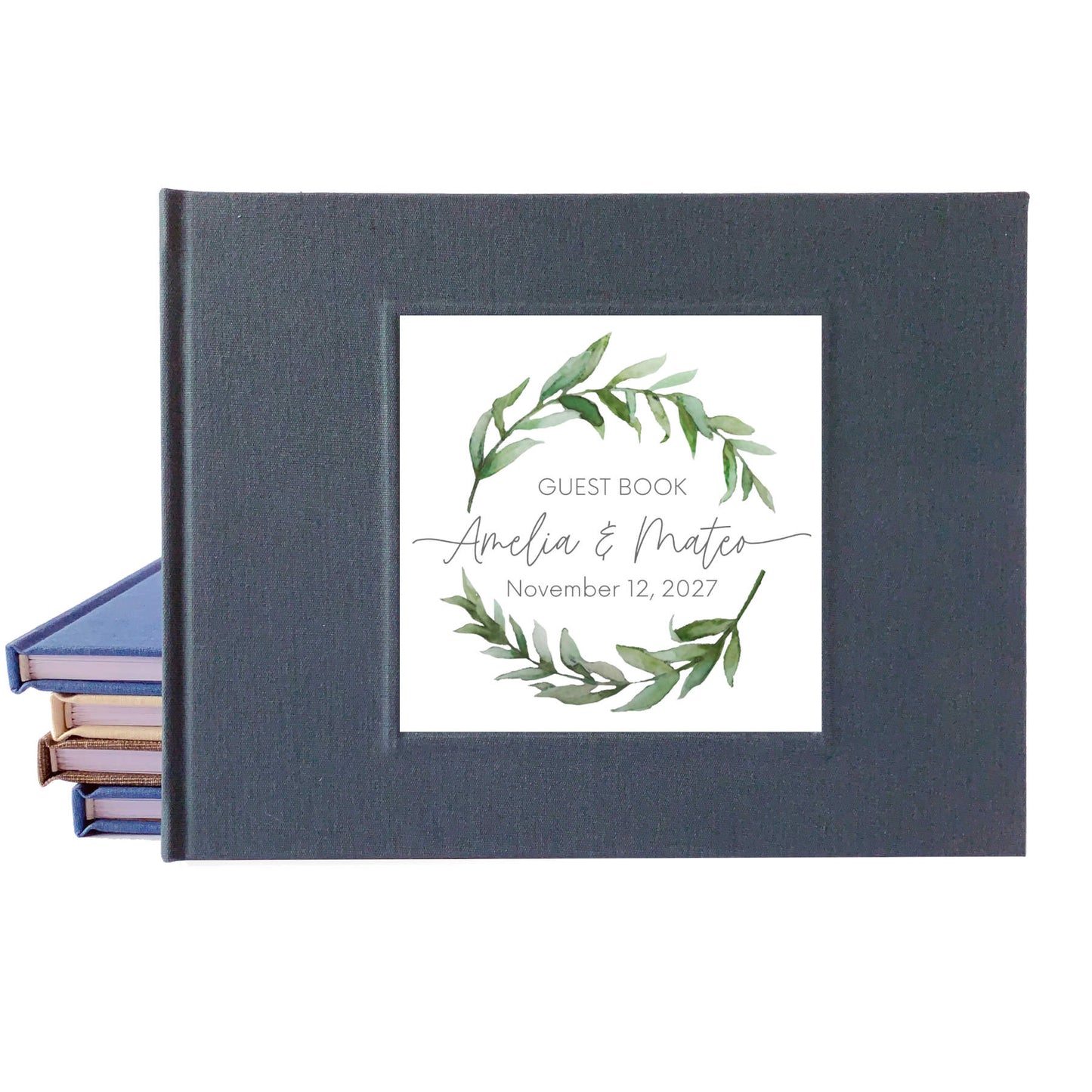 Dark gray linen wedding guest book with a personalized watercolor wreath design on the front that uses a script font for the names of the bride and groom.
