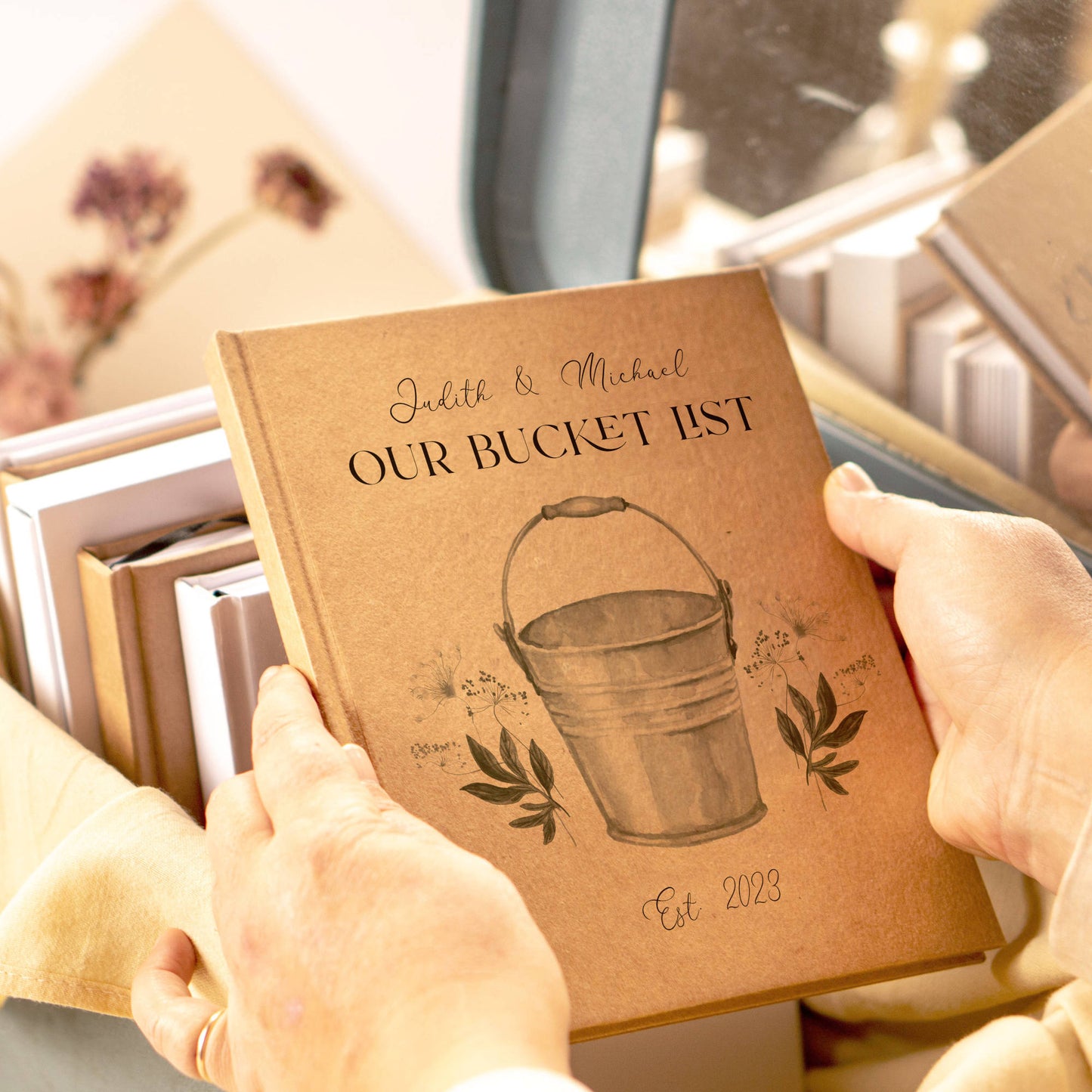 Hands holding a personalized bucket list book for the couple. Unique first anniversary gift.