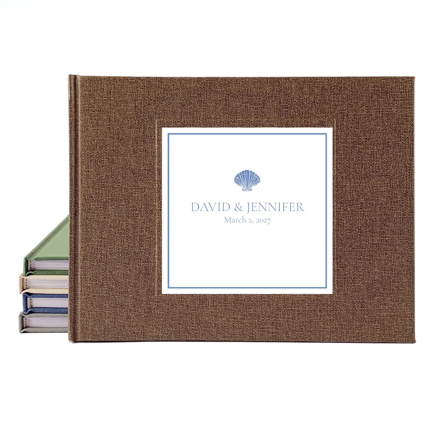 Personalized coastal wedding guest book with bride and groom's names, a seashell icon, and brown linen cover.