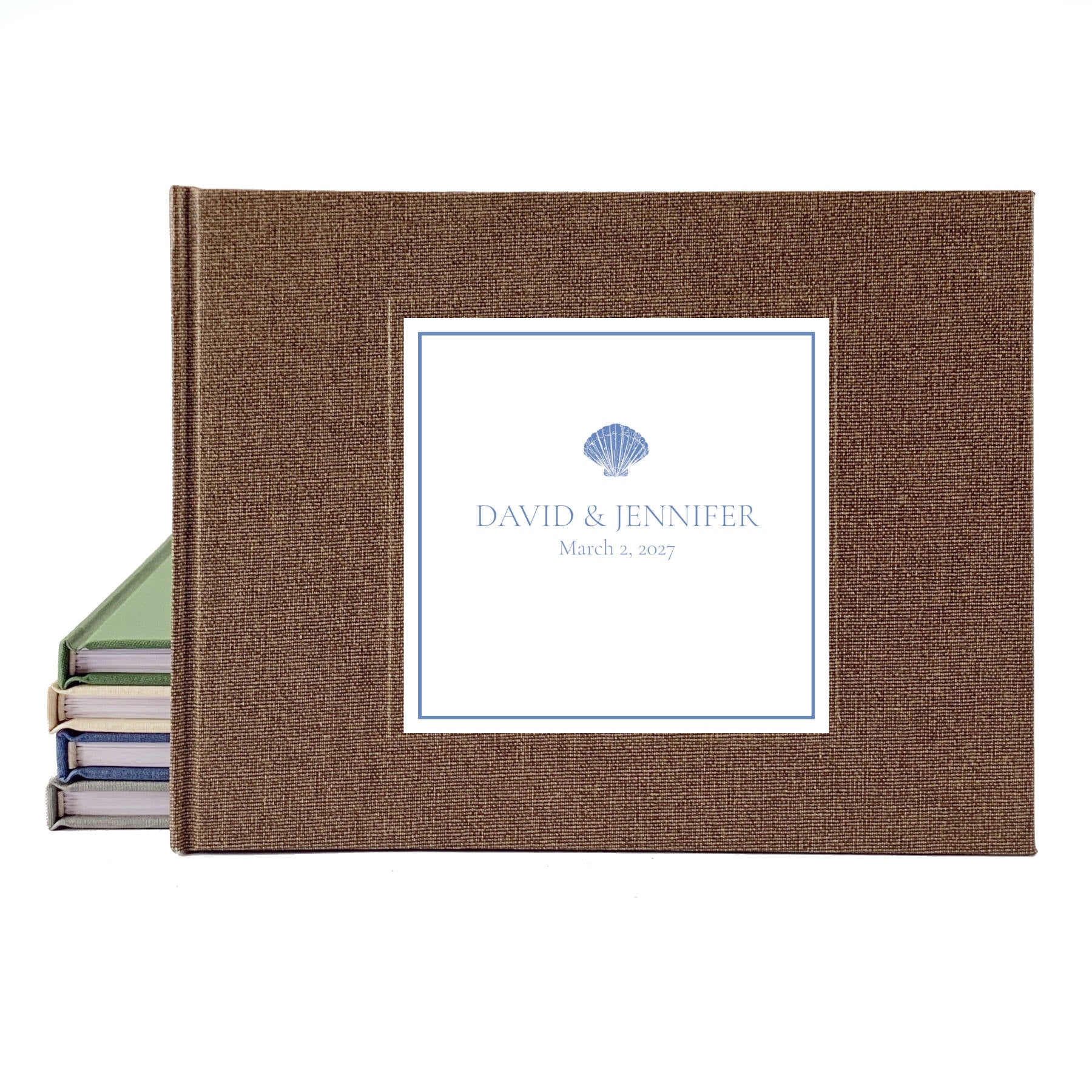 Personalized coastal wedding guest book with bride and groom's names, a seashell icon, and brown linen cover.