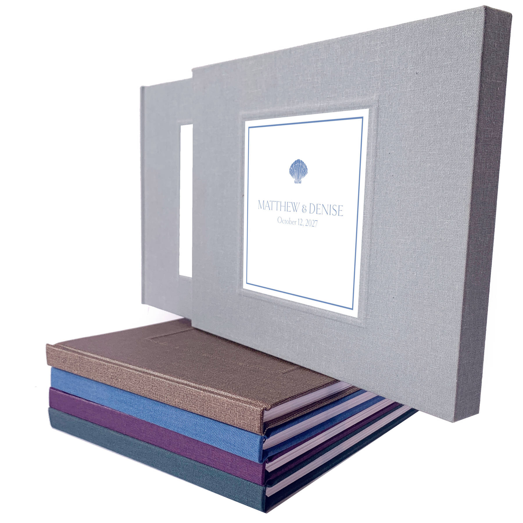 Dusty blue coastal design for a custom wedding guest book with minimalist cover design displayed on a stack of hand crafted guest books.