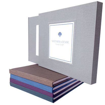 Dusty blue coastal design for a custom wedding guest book with minimalist cover design displayed on a stack of hand crafted guest books.