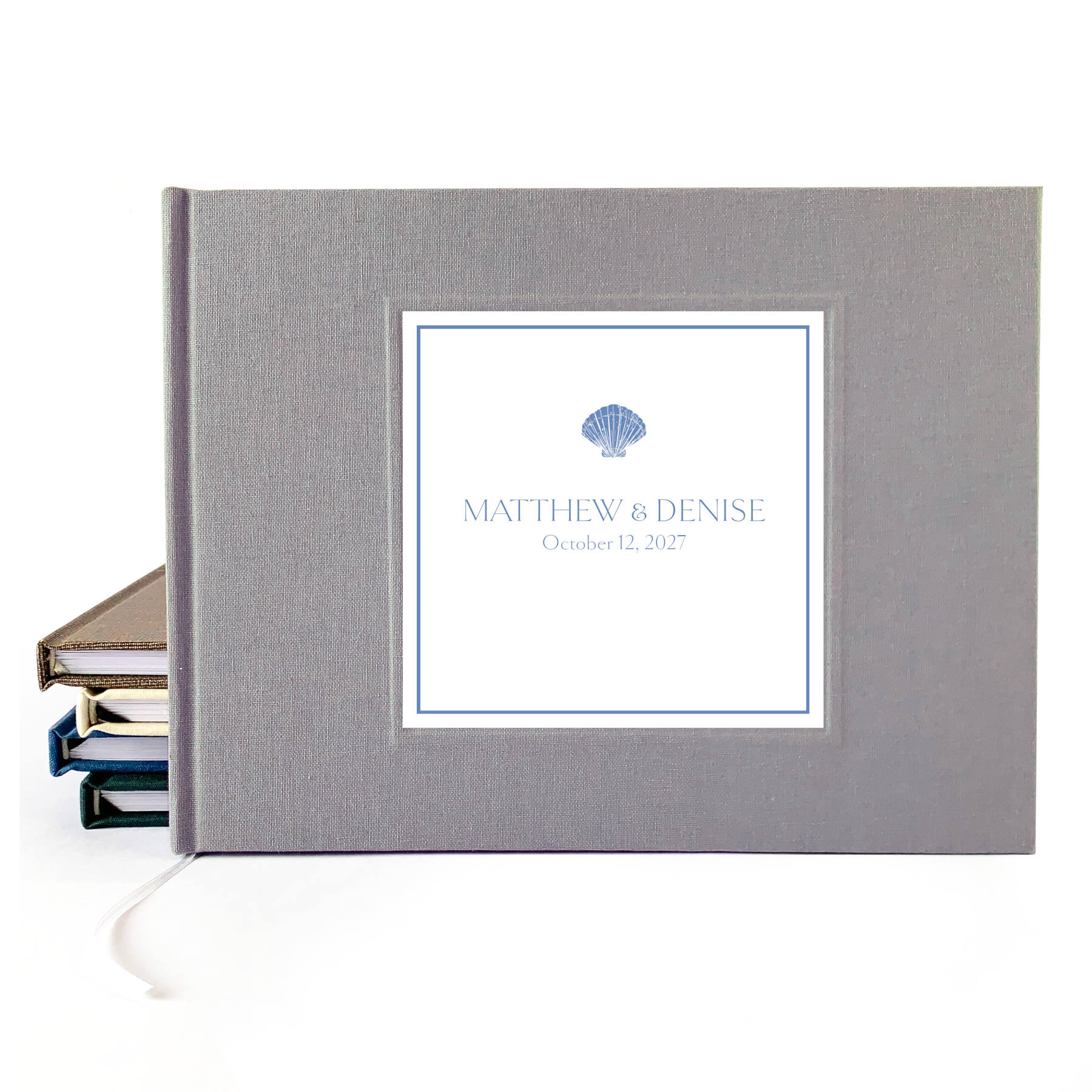 Gray linen hardback wedding guest book with custom names and wedding date on the cover. Seashell artwork incorporated.