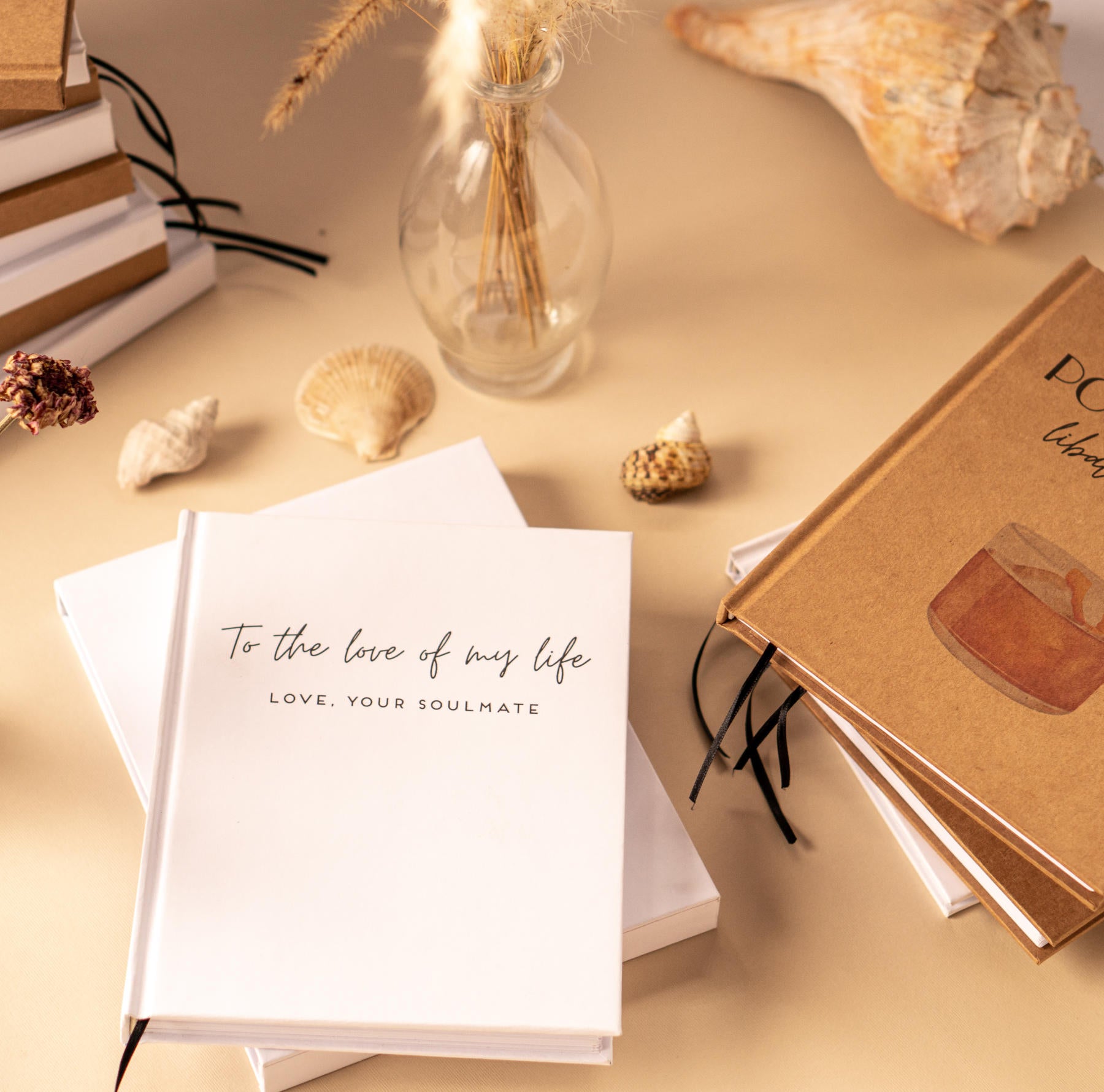 Custom journals on display with hardback white and kraft covers for gifting to book lovers.