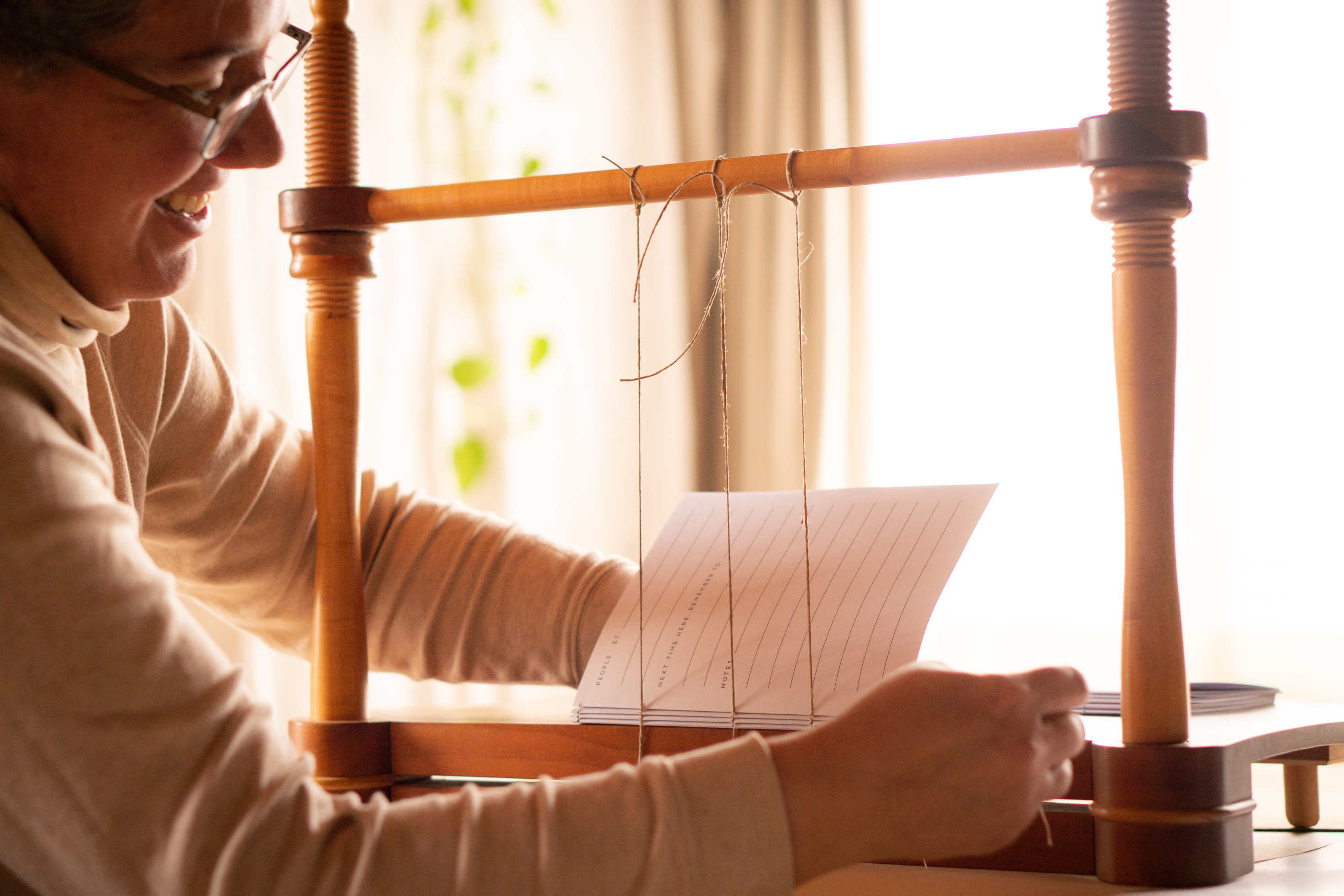 Hand-sewing a custom hand-bound book – crafted with care to turn cherished memories into timeless keepsakes.