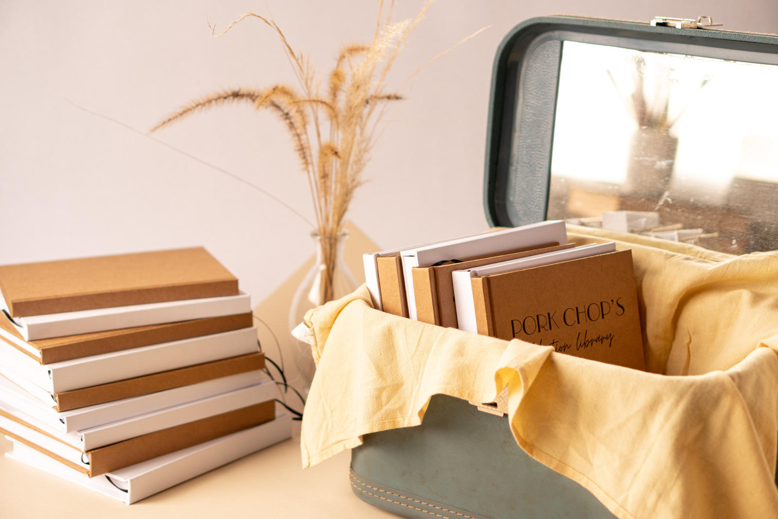 Custom hand made books, journals and notebooks ready to be personalized. 2 stacks, hardback covers in kraft and white. 