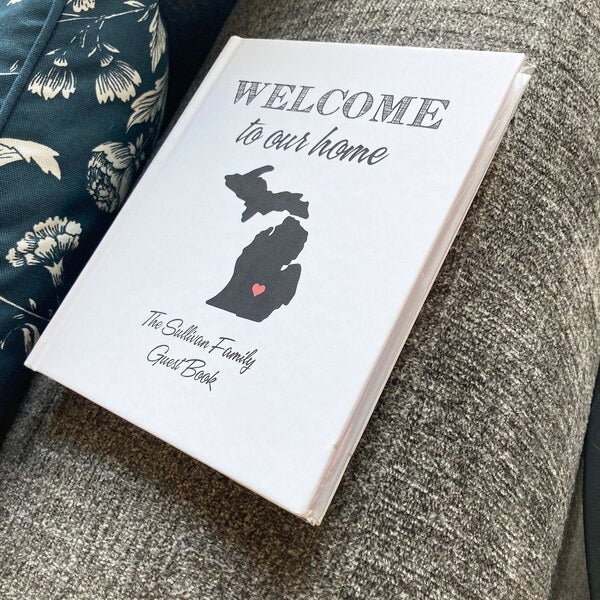 Personalized hand-bound guest book with Michigan  map silhouette and 'Welcome to our home' text on a textured surface