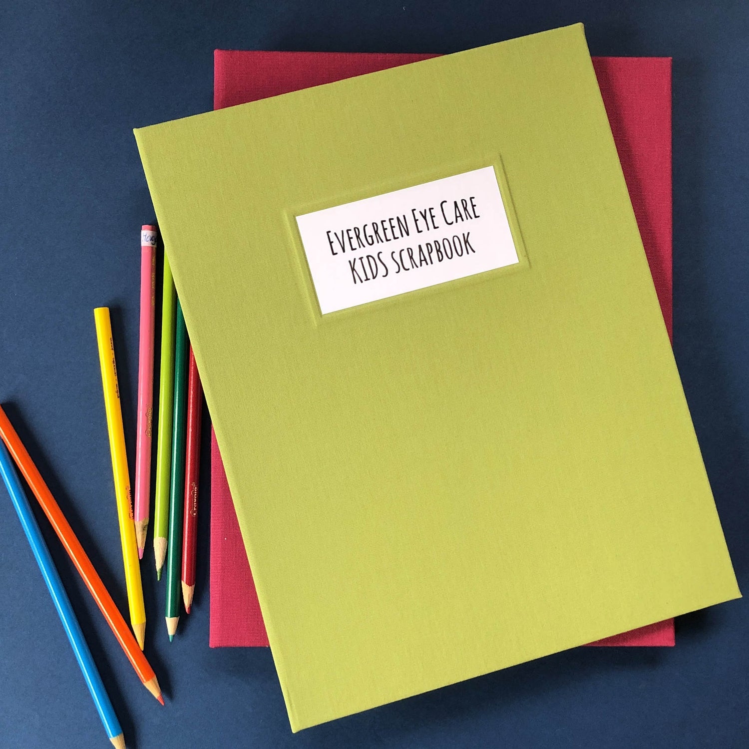 Personalized kids scrapbook album with brass screw posts and a hardback green linen cover.