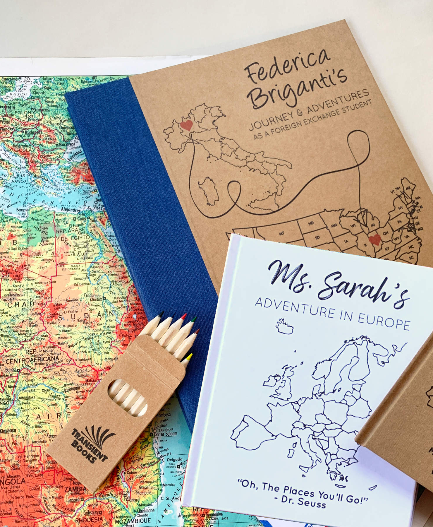 Small and large travel scrapbooks with custom maps on the cover for gifting to travelers.