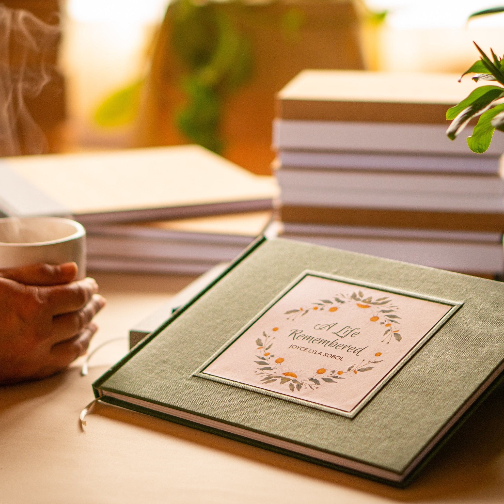 Green funeral guest book, personalized with custom text on the cover. Displayed on a welcome table waiting for guests to leave their meaningful memories.