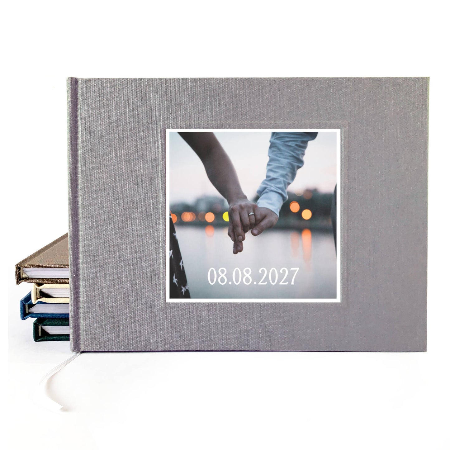 Gray linen wedding guest book with photo of couples' hands on the cover, and their wedding date.