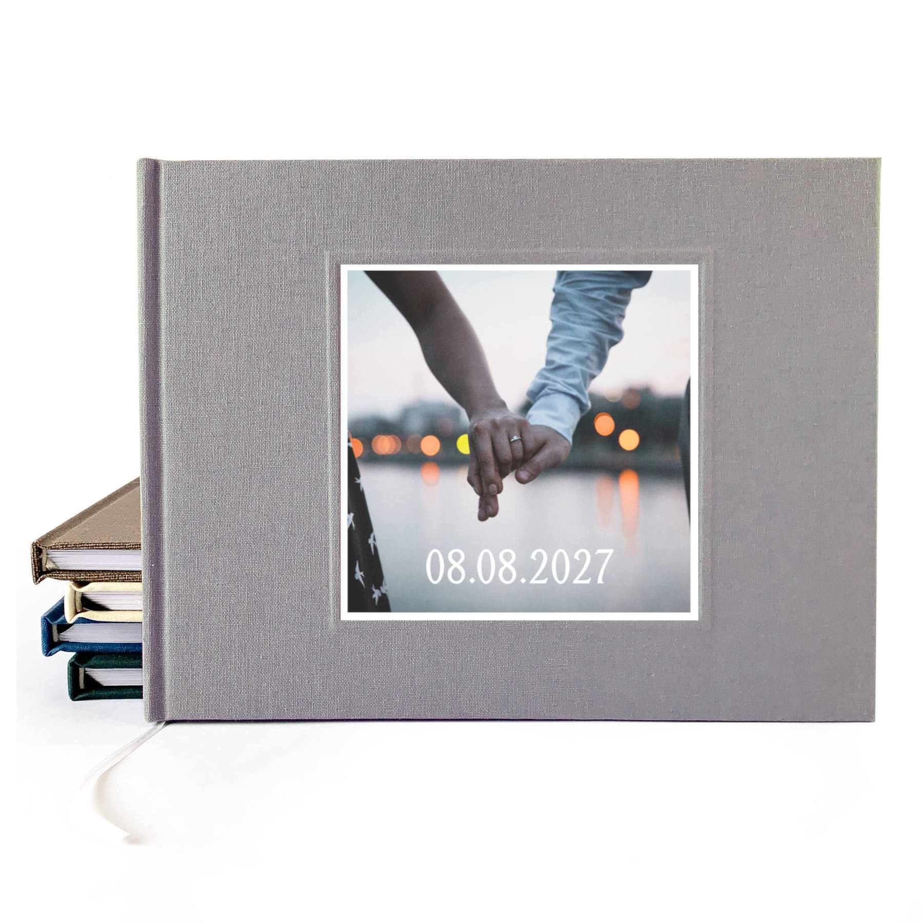 Gray linen wedding guest book with photo of couples' hands on the cover, and their wedding date.