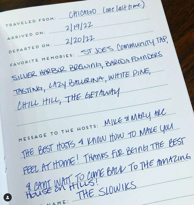 Handwritten notes on a page of a custom airbnb rental guest book with prompts that encourage guest to answer with travel details and host message.