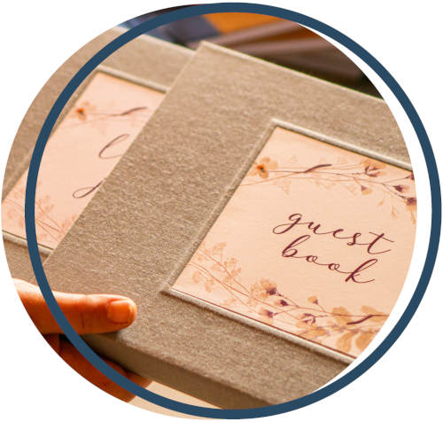 Close-up of a 'guest book' and its matching book slipcase with floral design and text.