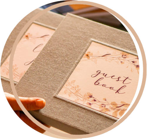 Gray linen covered guest book hand held, being put into a book slipcase. Handcrafted, modern flower design.