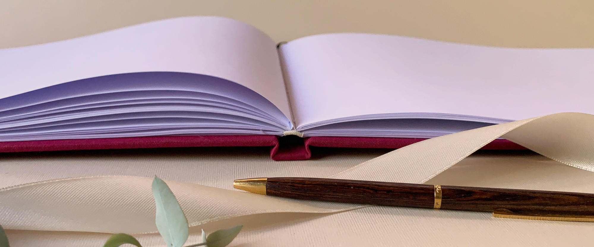 close up of Elegant custom wedding guest book swith textured linen cover open to show the layflat blank  pages available.