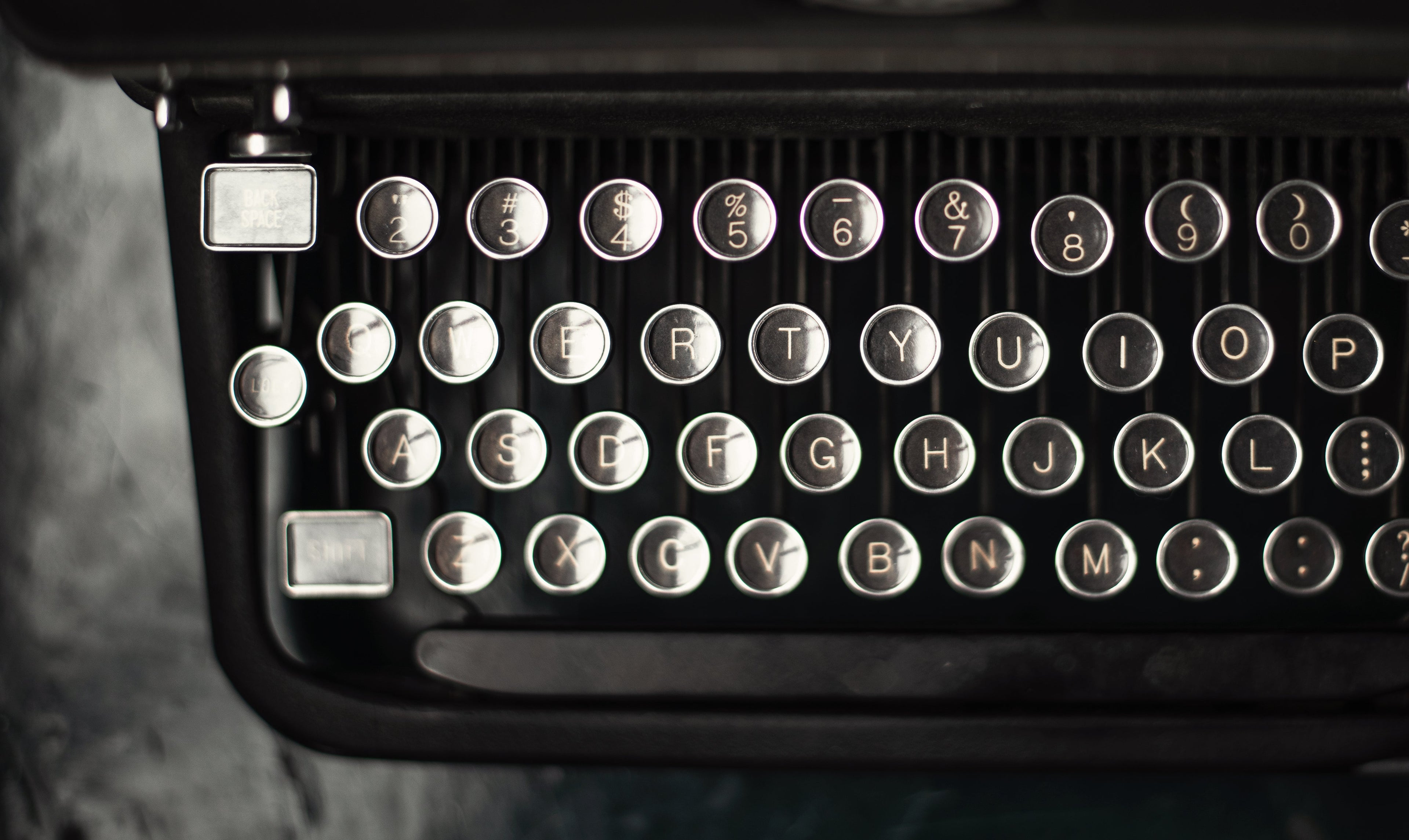 Close-up of a typewriter keyboard with visible keys. photo by samantha hurley.