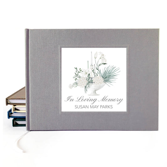 Personalized funeral guest book with white floral bouquet design and custom name and dates on the cover.