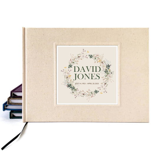 Cream linen memorial service guest book, hardback, personalized with  name on cover. The wildflower design commemorates the deceased with kindness. 