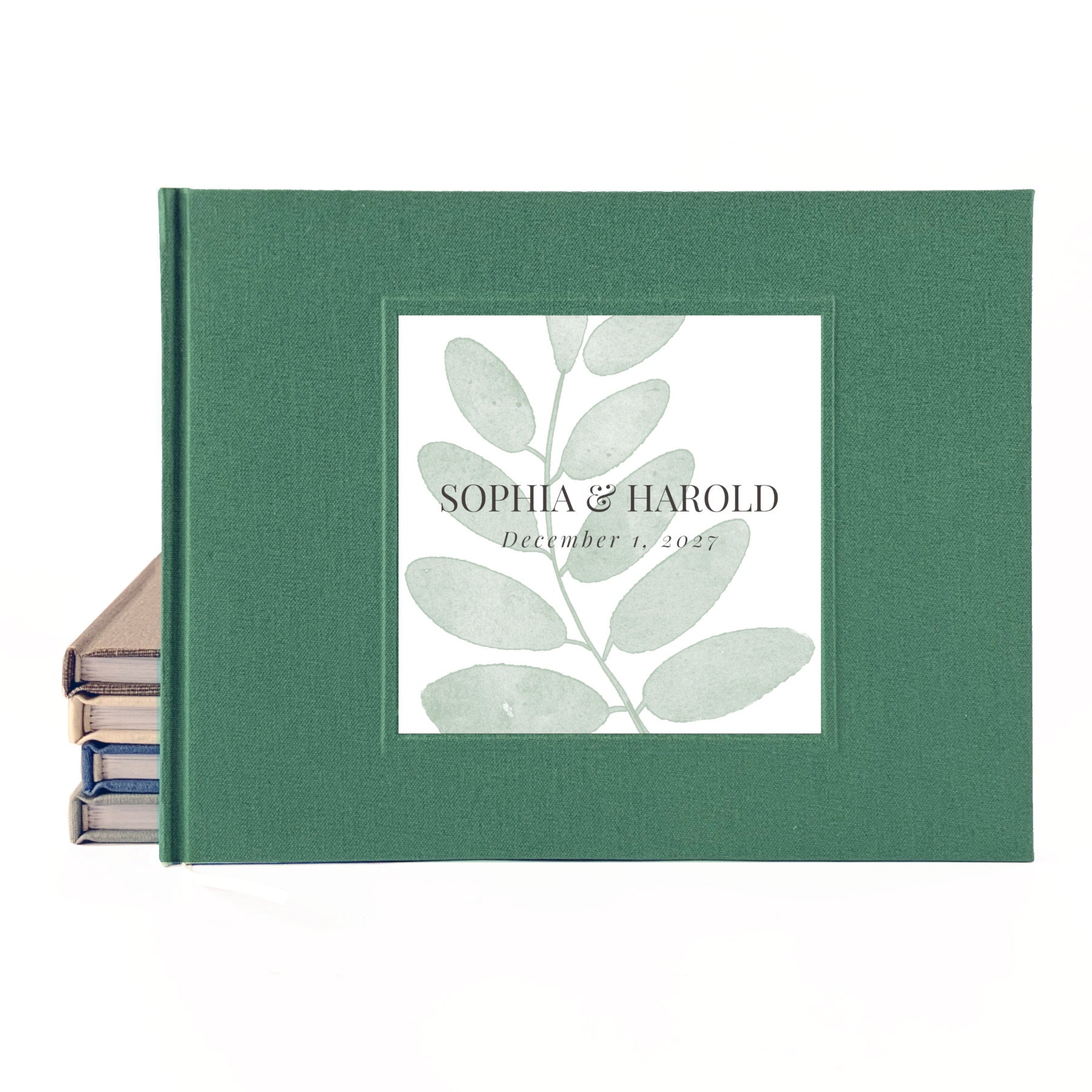 Green linen outdoor wedding guest book with simple leaf personalized on the front with the couple's names and wedding date.