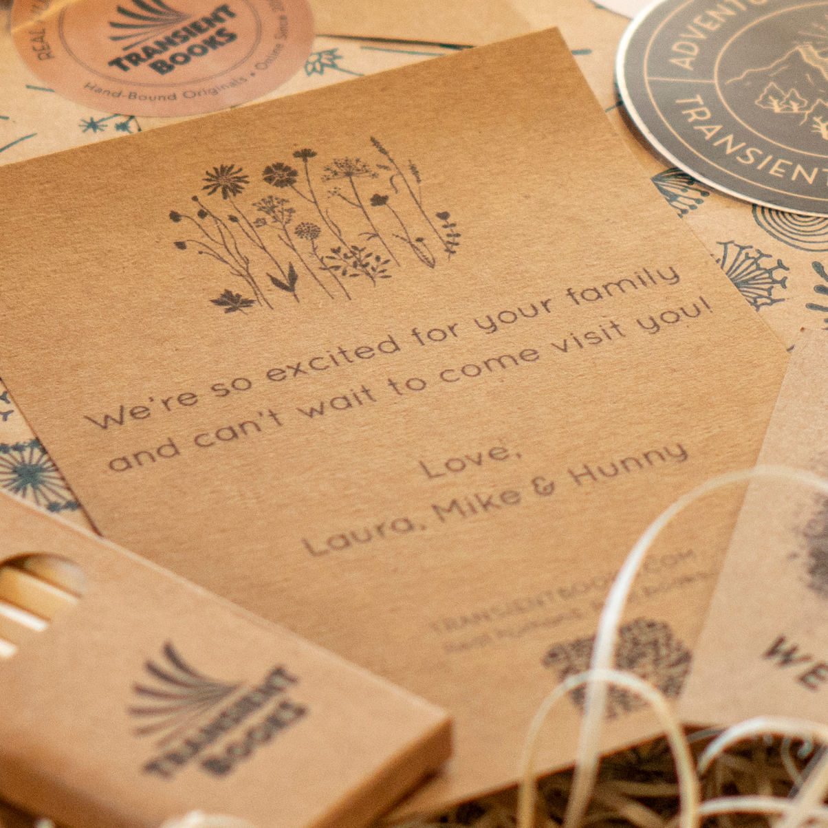 Personalized gift note on kraft paper with floral design and text on a matching gift box background