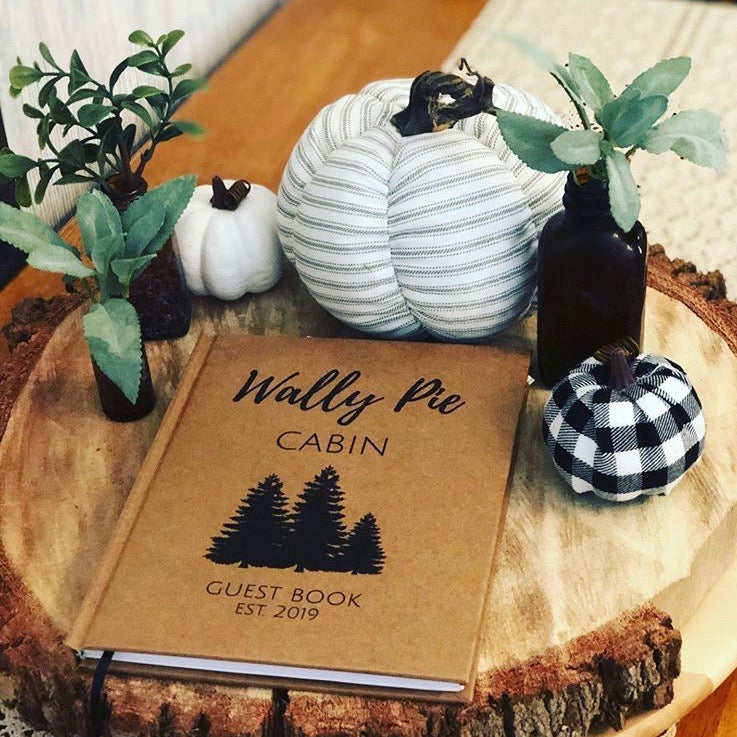 Personalized guest book for vacation home on welcome table with cozy decor, creating an inviting atmosphere for guests.