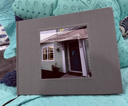 Personalized house guest book, gray linen cover, hardback and hand crafted, sitting on a couch.