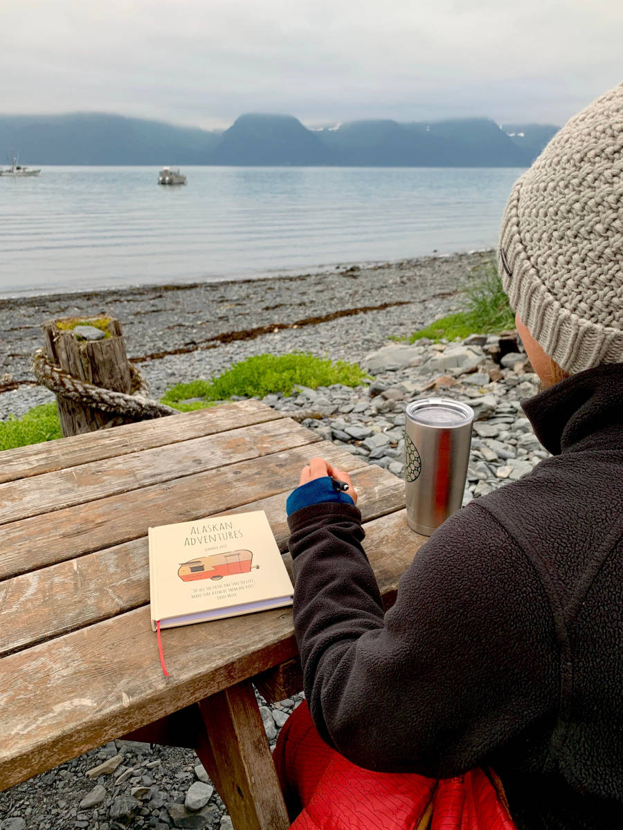 Woman on an Alaskan adventure holding a personalized traveler's notebook – perfect for documenting journeys and experiences.