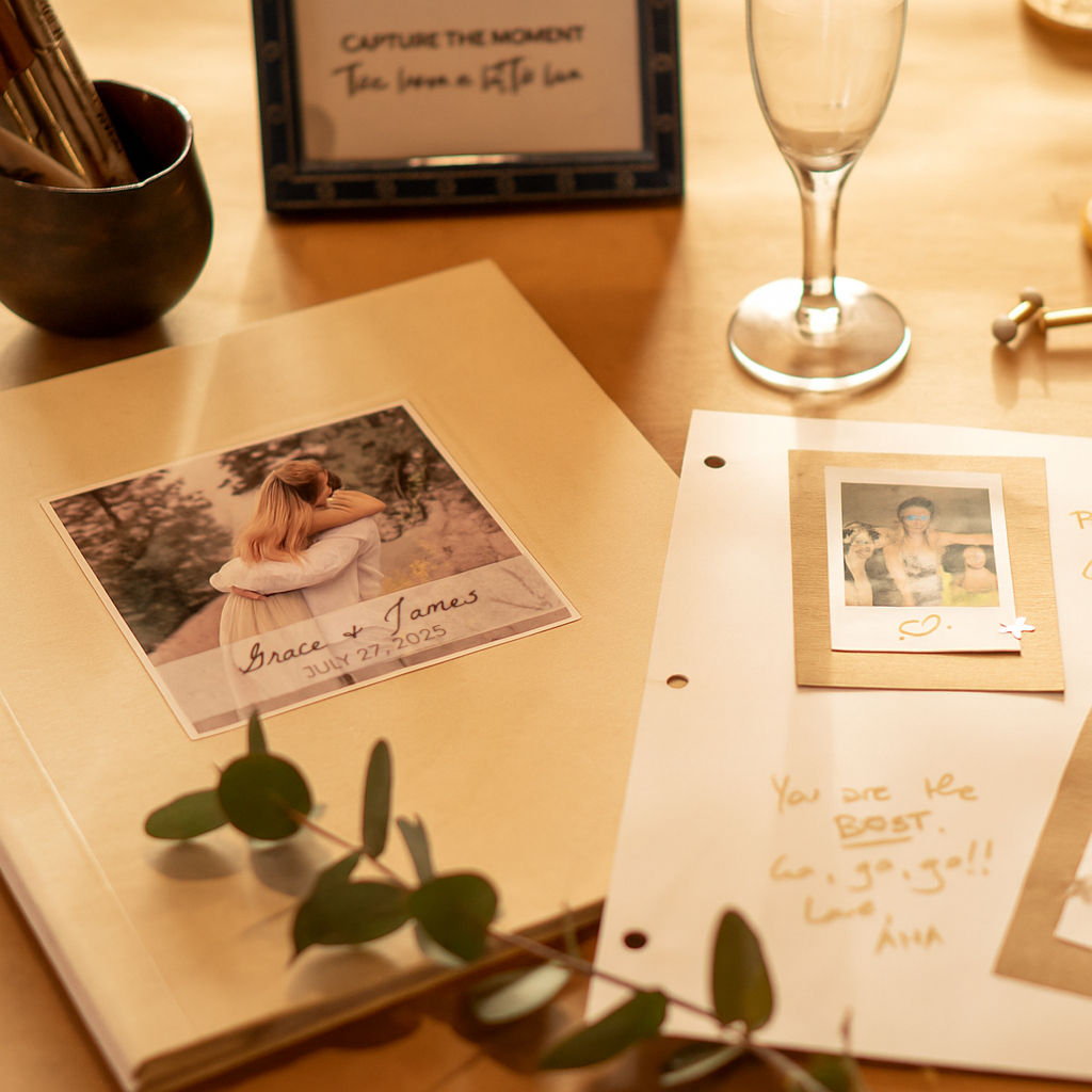 Personalized photo guest book for wedding displayed on table with pages written on by guests.