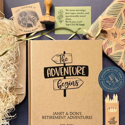 Personalized retirement journal with "The Adventure Begins" cover art, surrounded by gift box items: gift wrap, sticker, gift note, void fill, colored pencils.