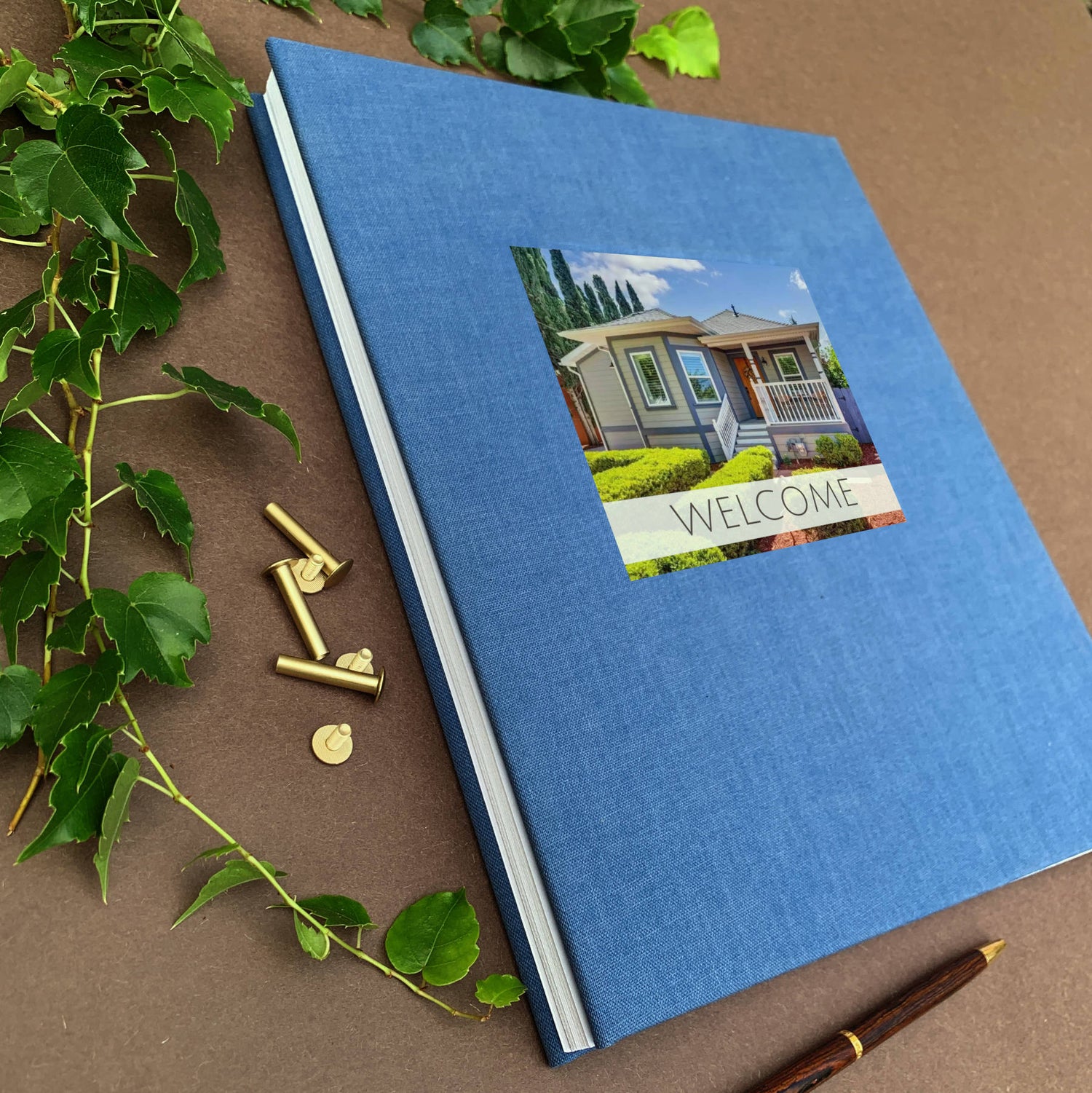 Personalized scrapbook album with brass screw posts and a hardback blue linen cover.