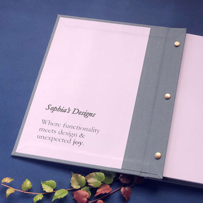 Personalized presentation portfolio with brass screw posts open on a decorated table with personalized text printed on the inside front cover.
