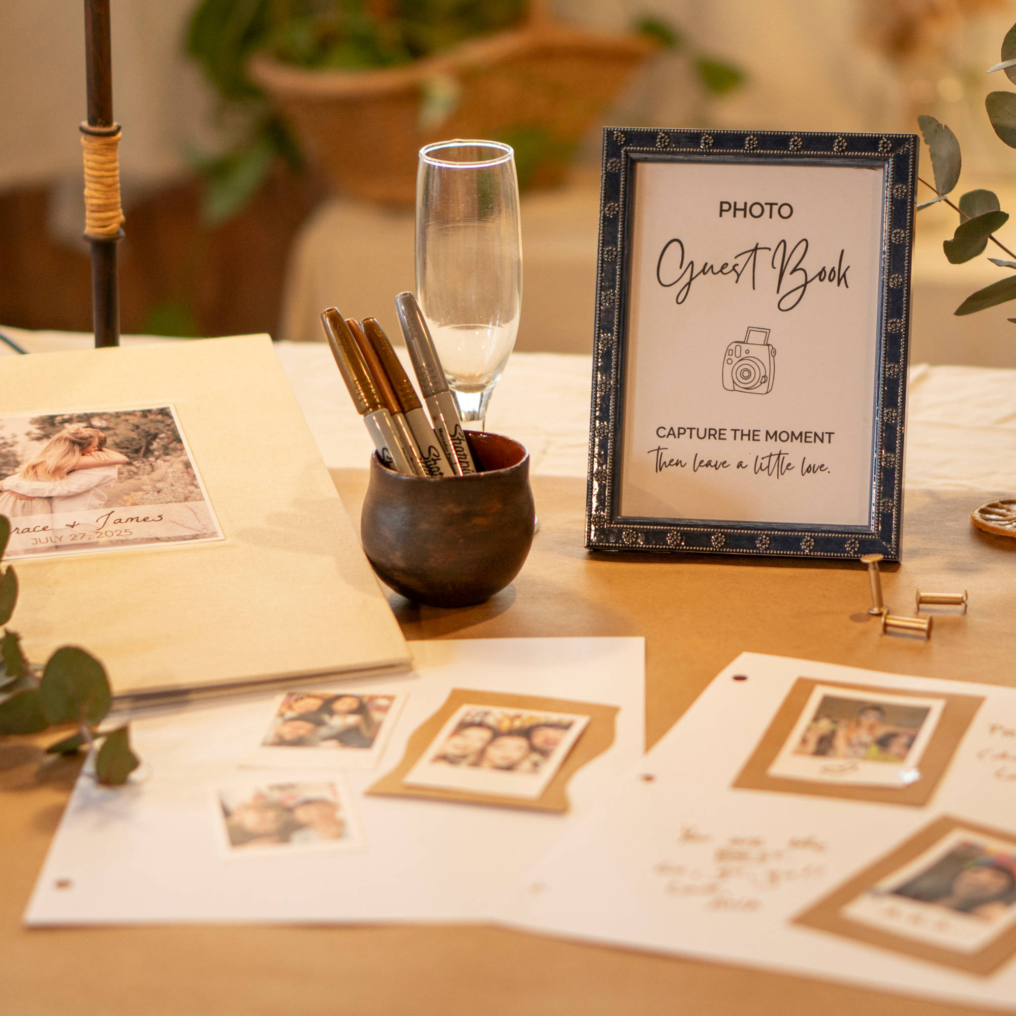 Table sign on wedding guest book table inviting guests to participate in the wedding photo guest book. Displayed with pens, pages, brass screw posts, and the photo guest book.