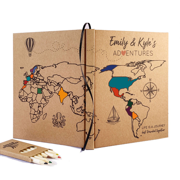 Personalized travel journal with world map design and colored pencils on a white background. Handbound, custom made, hardback cover.