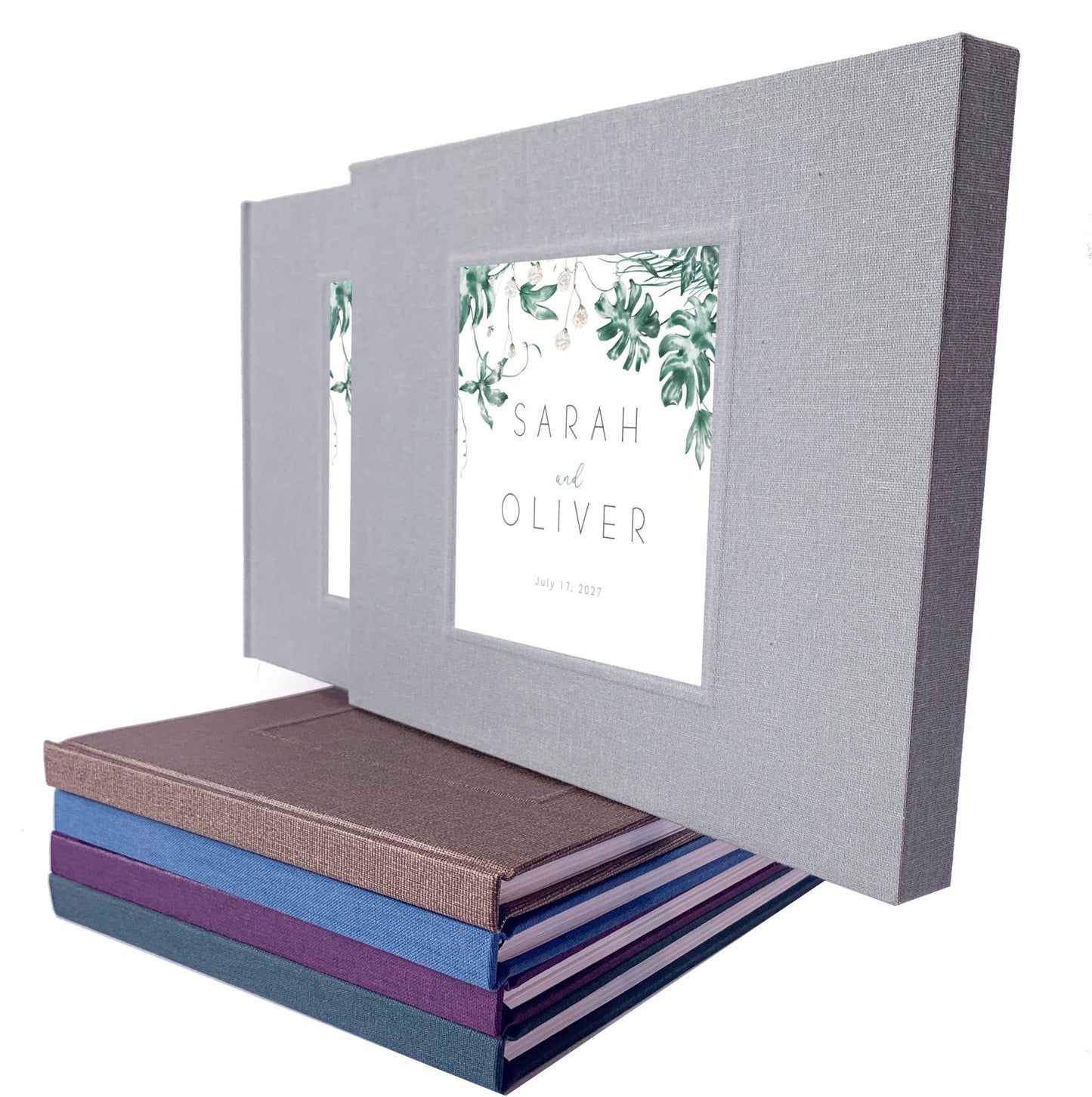 Tropical wedding guest book with printed inlay leaf design and custom names on a gray linen cover, housed in a matching book slipcase.