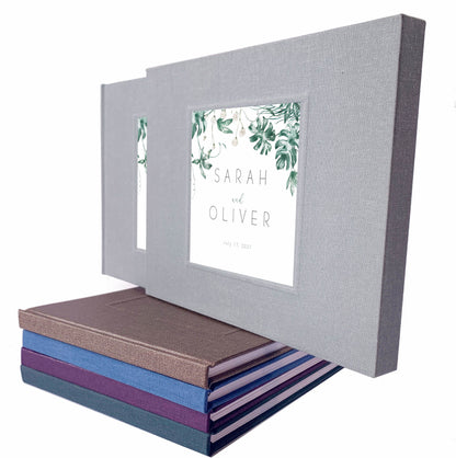 Tropical wedding guest book with printed inlay leaf design and custom names on a gray linen cover, housed in a matching book slipcase.