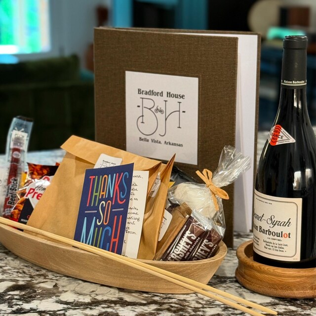 Personalized welcome book for airbnb on a welcome table at a vacation home with other welcome gifts for guests.
