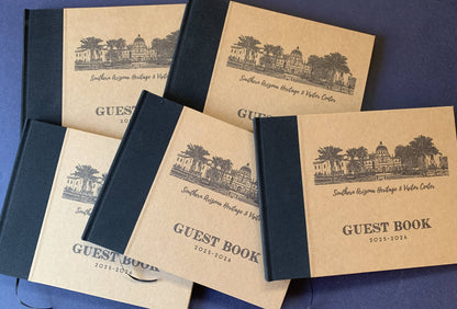 Set of personalized wholesale guest books with custom artwork and text on the covers on a blue background